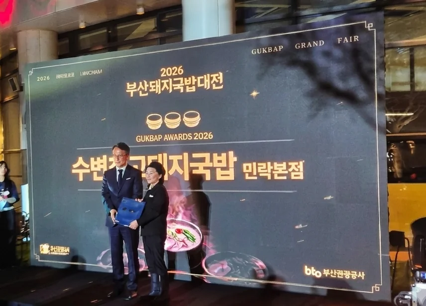 2026 부산돼지국밥대전 어워즈 무대 스크린에 수변최고돼지국밥 민락본점이 소개되고 상패를 전달받는 모습