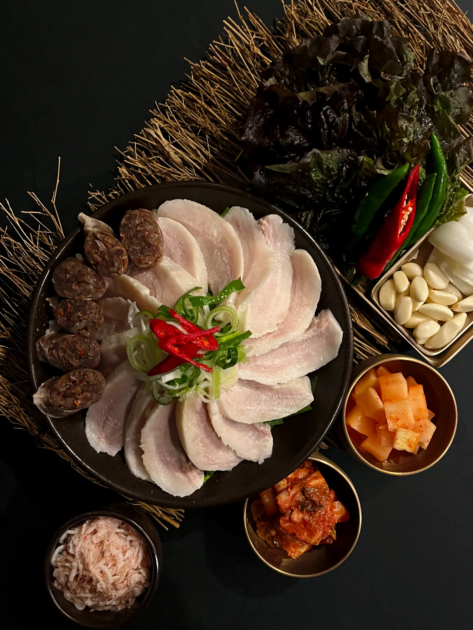 부추와 고추를 올린 항정수육과 순대, 쌈채소·깍두기·김치 상차림
